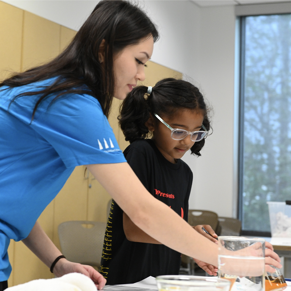 TGR Learning Lab teacher helping students with a science project.