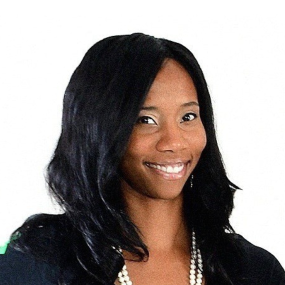 Smiling woman with long black hair wearing a pearl necklace against a white background.